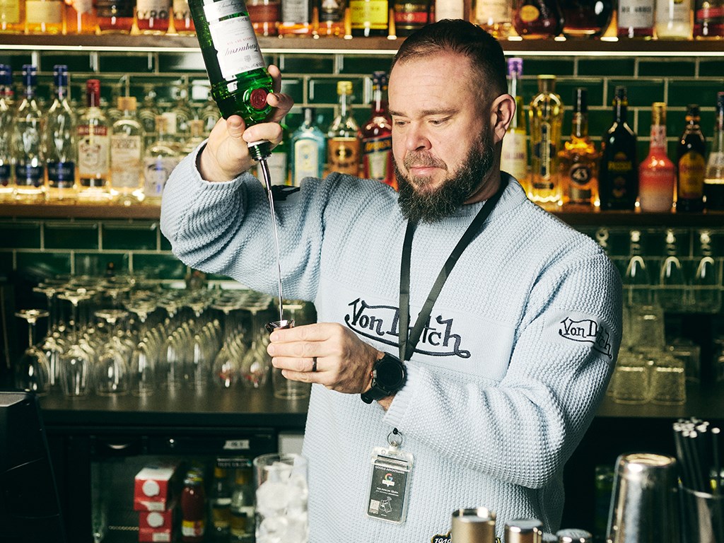 Henkilö tekee drinkkiä baarin takana