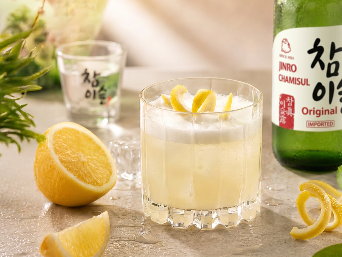 Soju Sour -cocktail vaahdolla ja sitruunankuorella sekä sojupullo